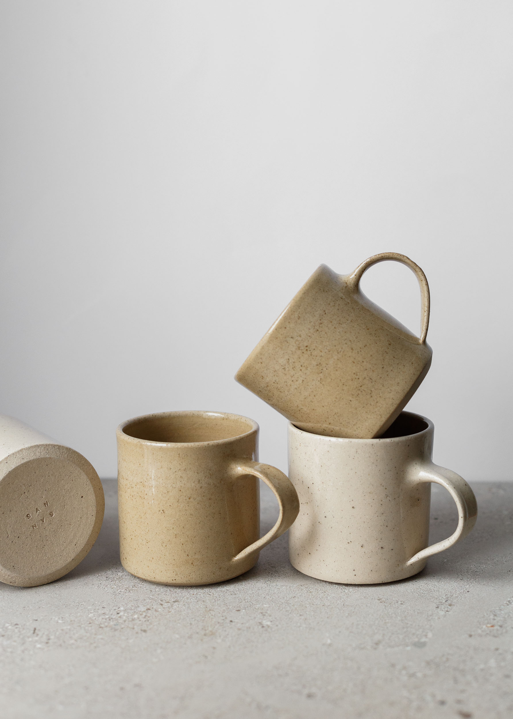 Speckled brown and speckled off-white mugs